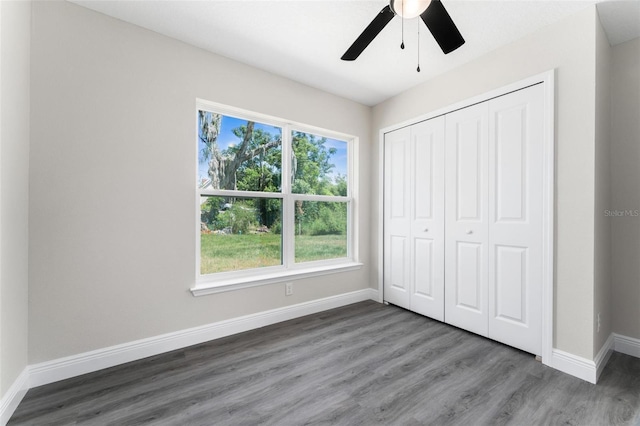 unfurnished bedroom featuring dark hardwood / wood-style flooring, a closet, and ceiling fan