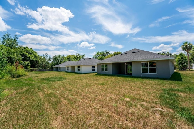 rear view of property featuring a yard