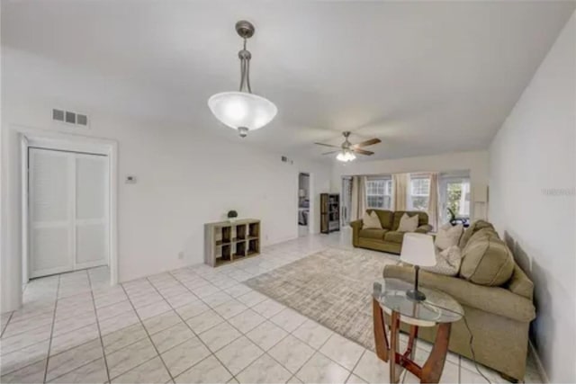 living area with ceiling fan, visible vents, and light tile patterned flooring