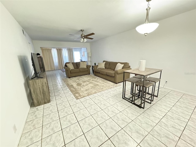 living room with light tile patterned floors, visible vents, baseboards, and ceiling fan