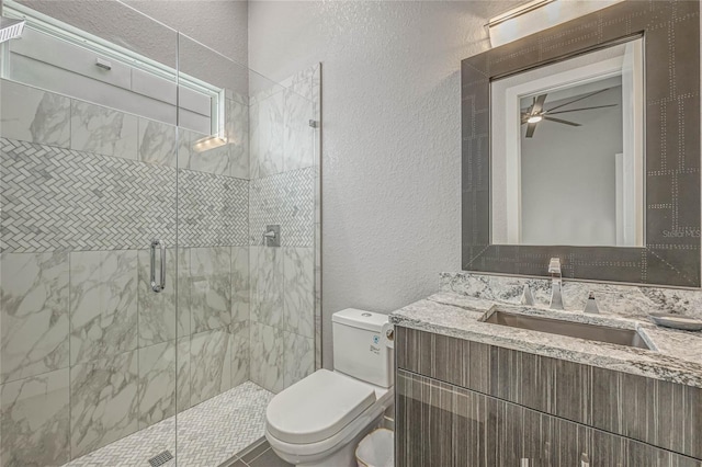 bathroom with vanity, toilet, an enclosed shower, and ceiling fan