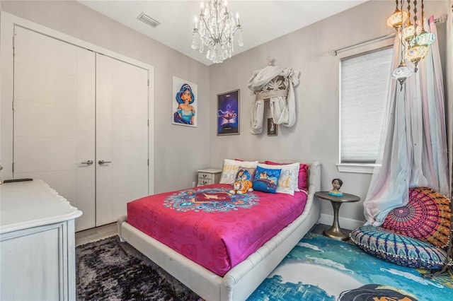 bedroom with an inviting chandelier and a closet