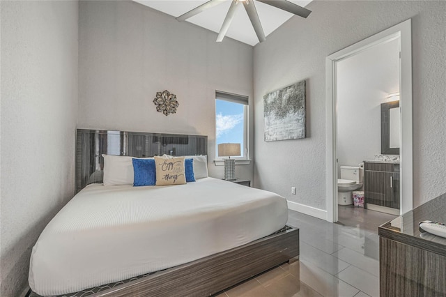 bedroom with connected bathroom, tile patterned floors, and ceiling fan