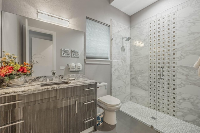 bathroom with vanity, toilet, and a shower with door