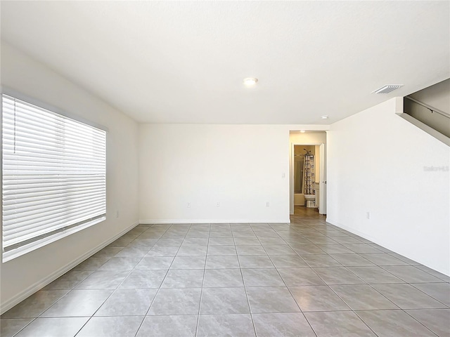 unfurnished room with light tile patterned flooring and visible vents