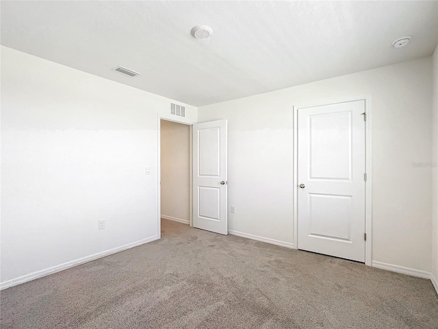 unfurnished bedroom featuring visible vents, carpet flooring, and baseboards