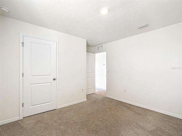 unfurnished bedroom featuring carpet and a textured ceiling