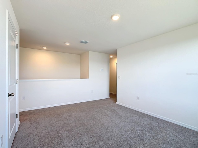 unfurnished room with carpet flooring, baseboards, and visible vents