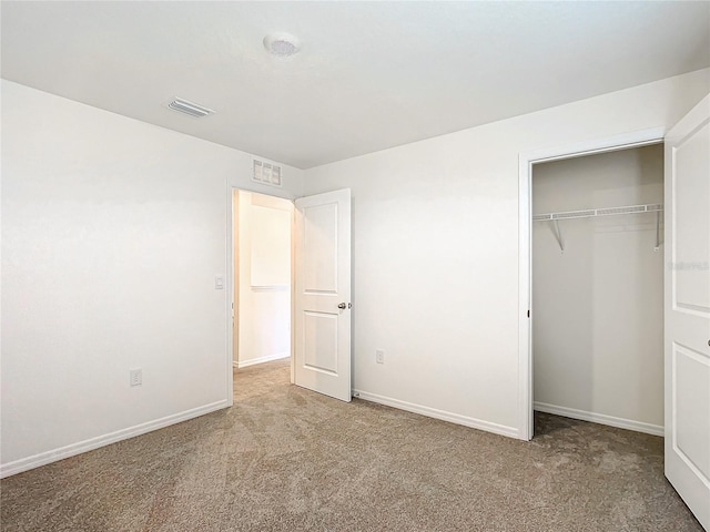 unfurnished bedroom featuring light carpet and a closet