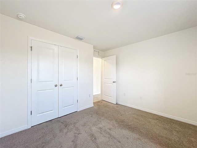 unfurnished bedroom with a closet and carpet flooring