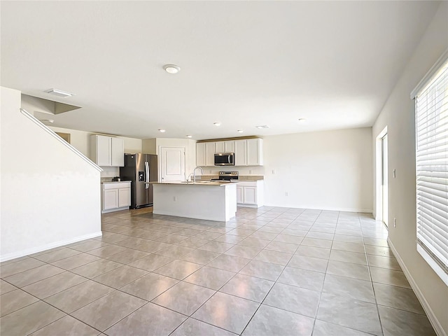 unfurnished living room with light tile patterned floors, visible vents, baseboards, and a sink