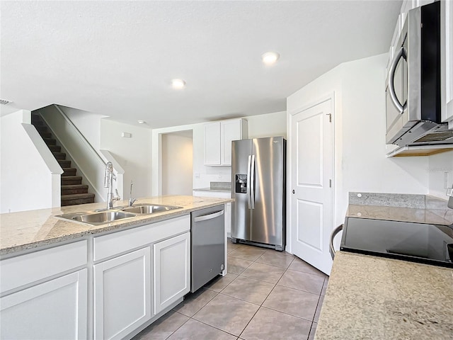 kitchen featuring white cabinetry, sink, stainless steel appliances, and light tile patterned flooring