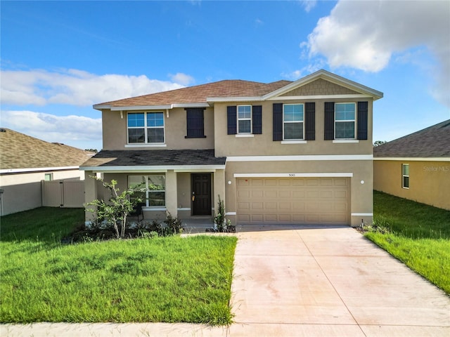 view of front of property featuring a front yard, fence, stucco siding, concrete driveway, and a garage