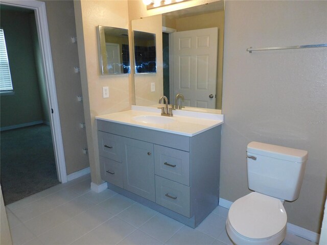 bathroom featuring toilet, vanity, and tile patterned floors