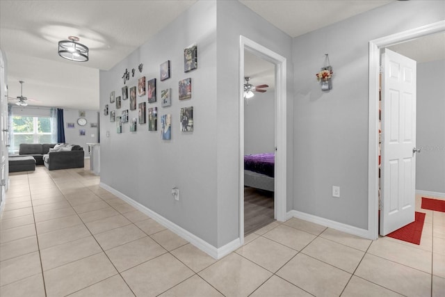 hall featuring light tile patterned flooring and a textured ceiling