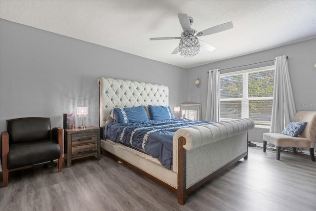 bedroom featuring a textured ceiling, ceiling fan, and dark wood-type flooring