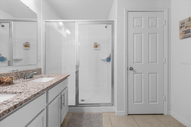 bathroom featuring tile patterned flooring, vanity, and a shower with shower door