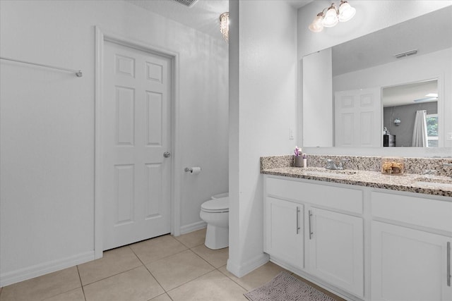 bathroom with tile patterned flooring, vanity, and toilet