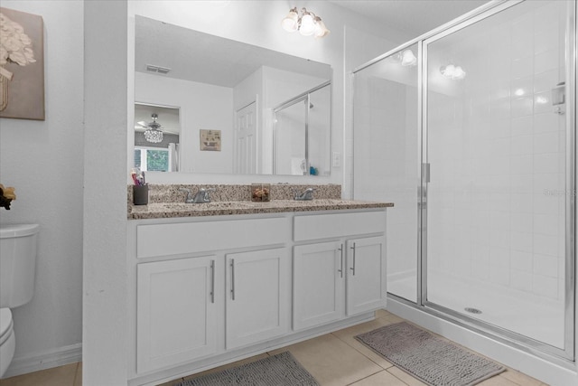 bathroom featuring vanity, tile patterned flooring, ceiling fan, toilet, and an enclosed shower