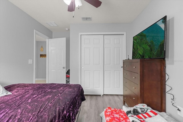 bedroom featuring ceiling fan, a closet, and light wood-type flooring