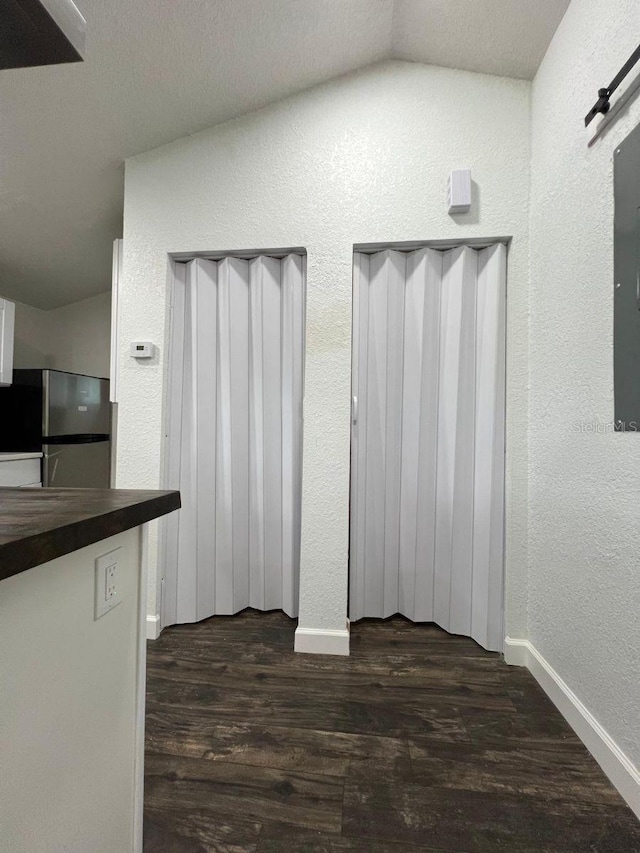 1526 Lakewood Rd, Davenport, FL 33837 - unfurnished dining area with a textured wall, dark wood-type flooring, and vaulted ceiling