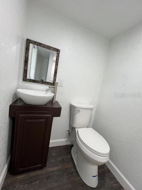 bathroom featuring hardwood / wood-style floors, vanity, and toilet