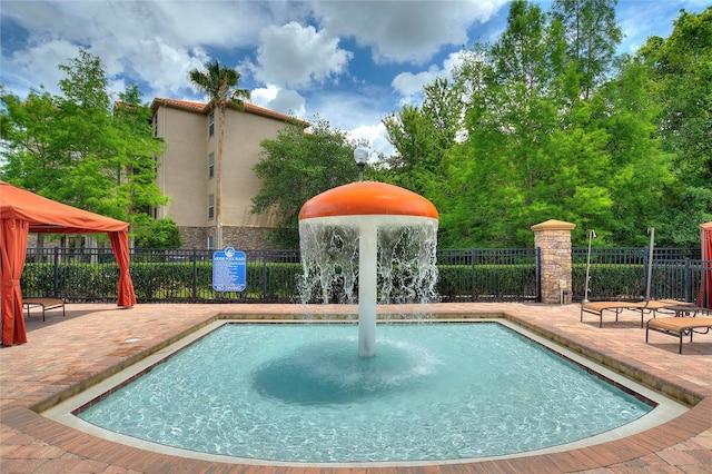 view of pool featuring pool water feature and a patio