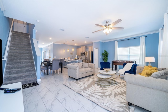 living room with ceiling fan and ornamental molding