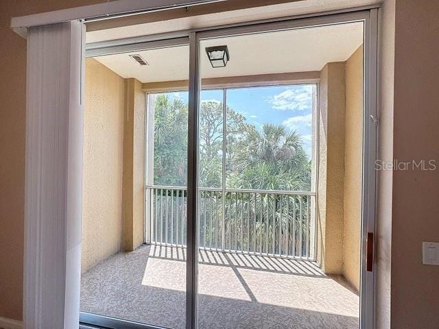 doorway to outside featuring a textured wall