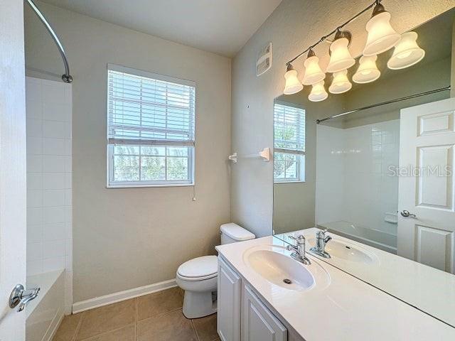 full bathroom featuring bathtub / shower combination, tile flooring, toilet, and vanity