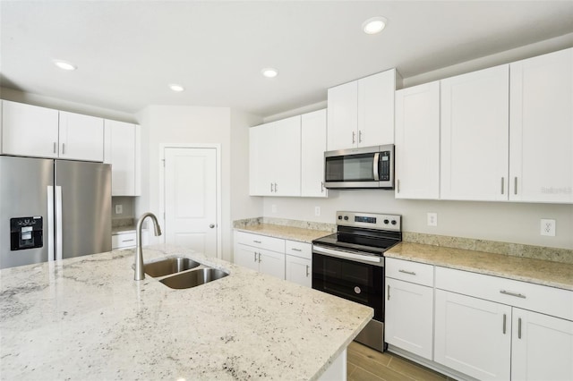 kitchen with light wood-type flooring, white cabinetry, appliances with stainless steel finishes, and sink