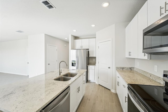 kitchen with appliances with stainless steel finishes, light hardwood / wood-style floors, sink, and white cabinets