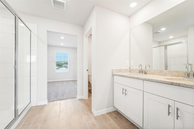 bathroom with walk in shower, wood-type flooring, vanity, and toilet