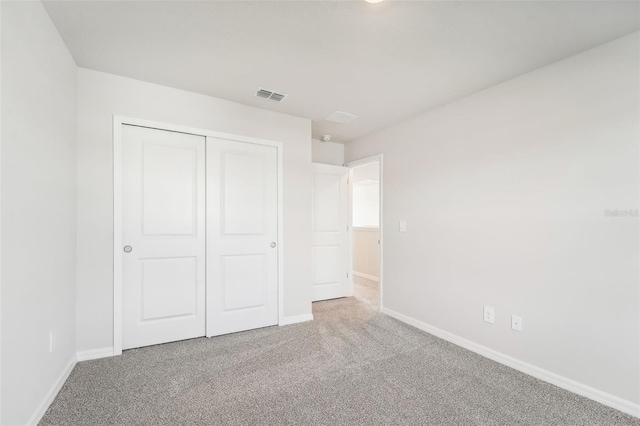 unfurnished bedroom featuring carpet and a closet