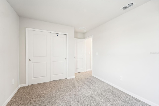 unfurnished bedroom with carpet and a closet