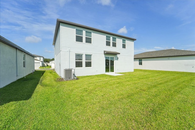 back of property featuring central AC and a yard