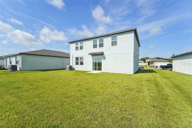 rear view of house featuring central AC unit and a yard