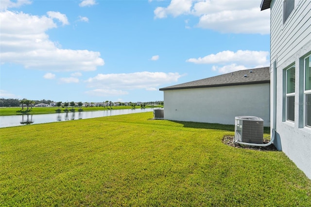 view of yard featuring a water view and central air condition unit