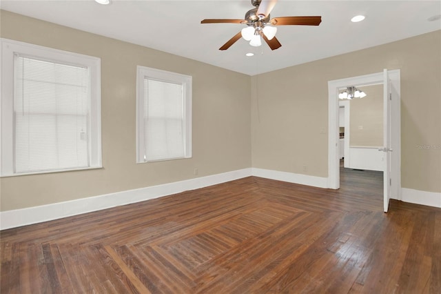 empty room featuring dark wood-type flooring and ceiling fan with notable chandelier