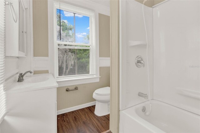 full bathroom with washtub / shower combination, toilet, vanity, and hardwood / wood-style flooring