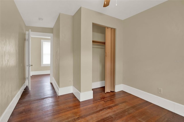 unfurnished bedroom with ceiling fan, dark hardwood / wood-style floors, and a closet