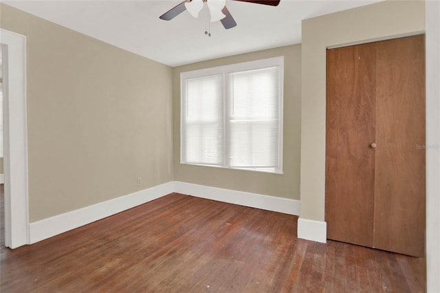 unfurnished bedroom with hardwood / wood-style flooring, ceiling fan, and a closet