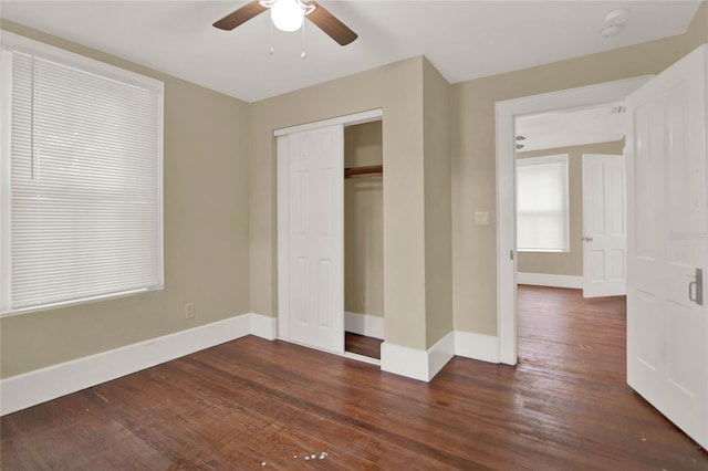 unfurnished bedroom with ceiling fan, dark hardwood / wood-style floors, and a closet