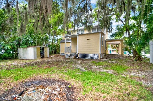 rear view of property with a storage unit