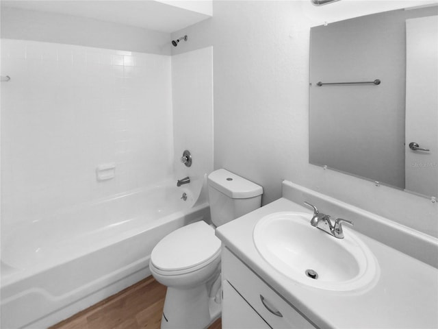 full bathroom featuring hardwood / wood-style floors, toilet, shower / washtub combination, and vanity