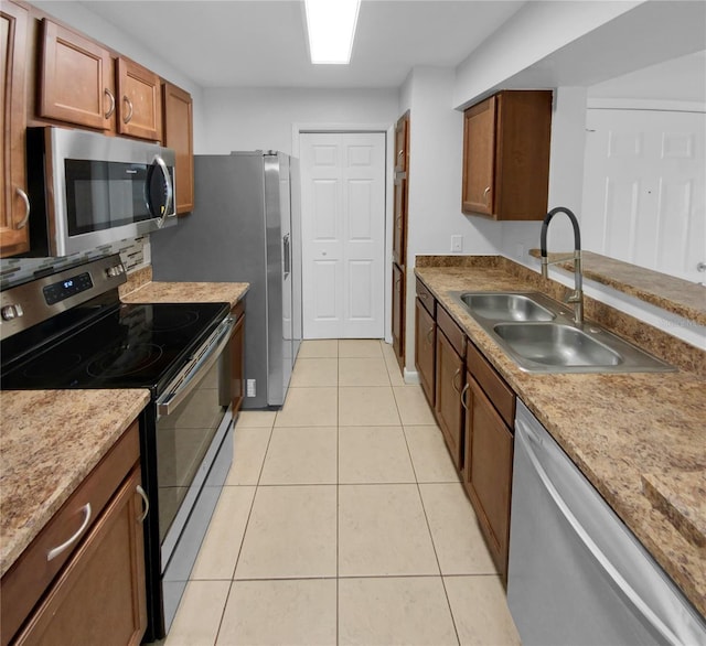 kitchen featuring sink, light tile patterned floors, and stainless steel appliances