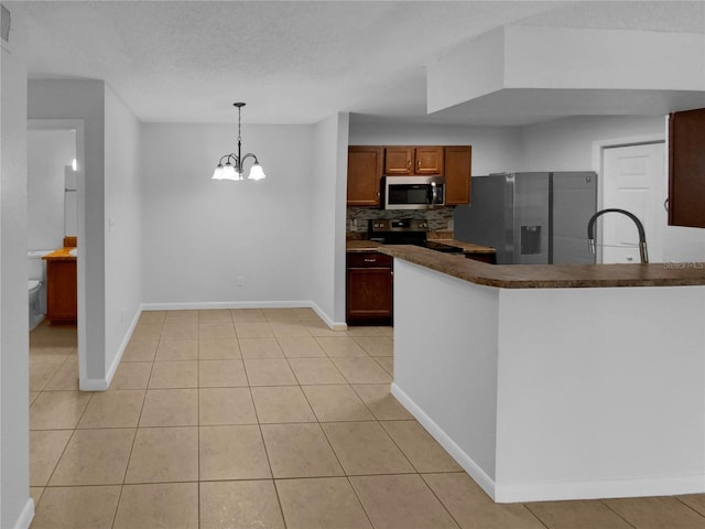 kitchen featuring pendant lighting, backsplash, sink, appliances with stainless steel finishes, and a chandelier