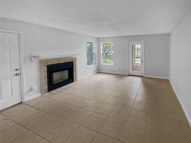 unfurnished living room featuring a textured ceiling, light tile patterned floors, and a fireplace