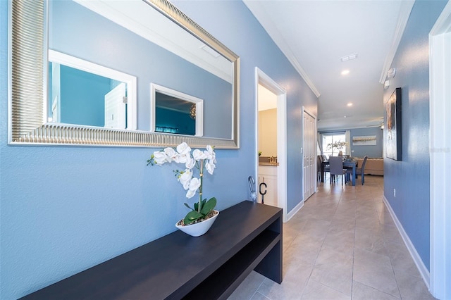 corridor featuring light tile patterned floors and ornamental molding