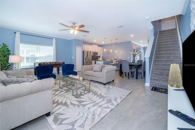 tiled living room with ceiling fan and crown molding